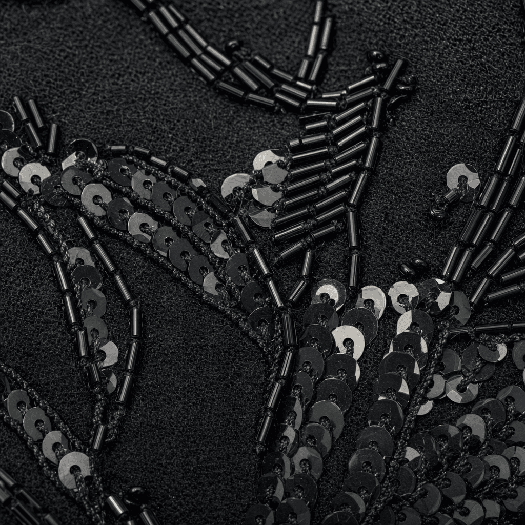 Macro detail of hand-applied black bugle beads and sequins on black wool — the embroidery technique used on the original Motown 25 stage jacket designed by Bill Whitten.